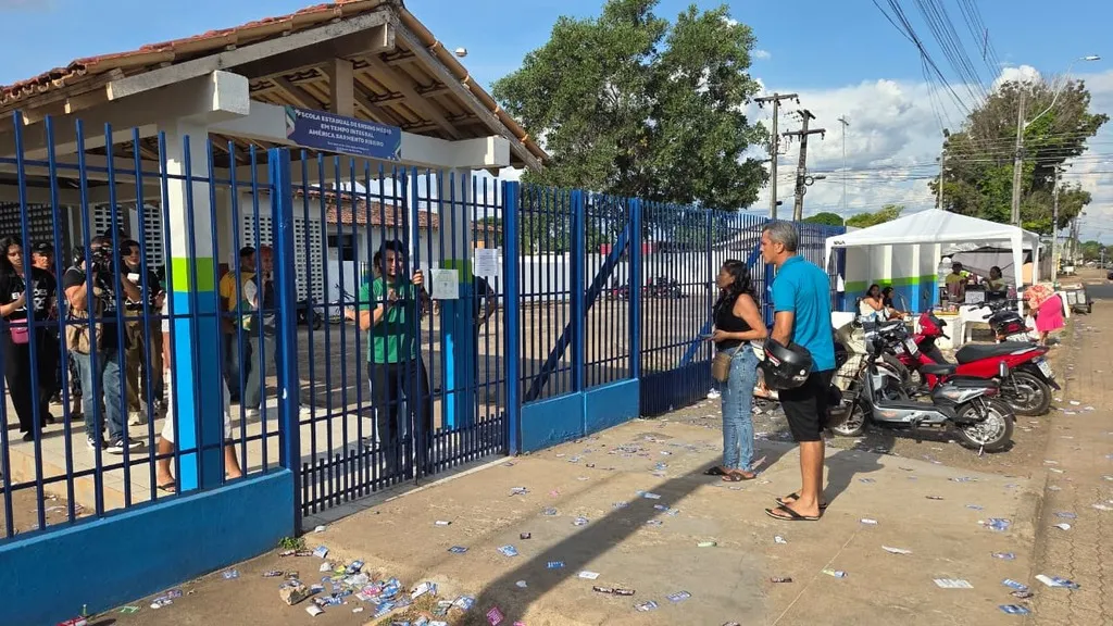 Imagem mostra eleitores em frente à portão de colégio eleitoral fechado